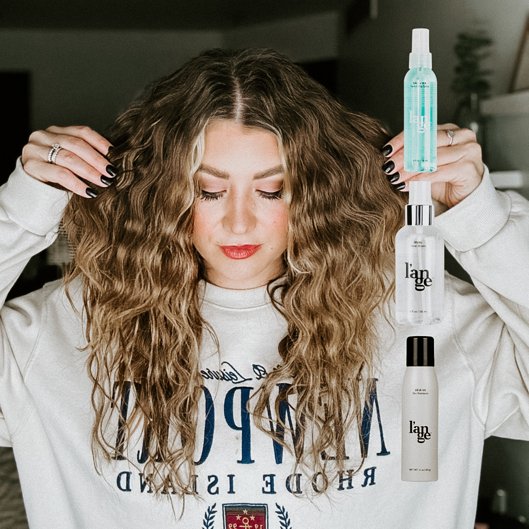 Savannah Kreger showing voluminous textured waves styled with L’ange hair products, holding L’ange Salt and Sea Texturizing Spray, L’ange Rival Heat Shield, L’ange Dry Shampoo, must-have styling essentials, shiny healthy hair, best L’ange products for volume and texture, everyday hair care, salon-quality results at home
