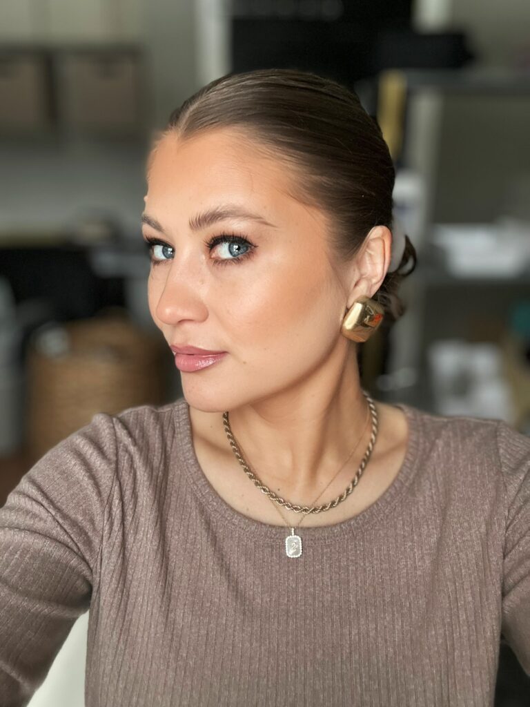 thesavannahk with slicked back hairstyle, neutral glam makeup, chunky gold earrings and layered necklaces, fashion and beauty inspiration