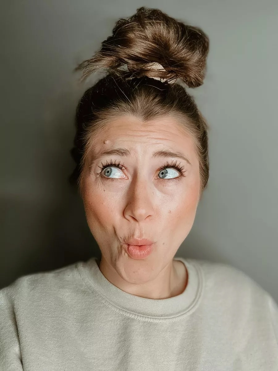 thesavannahk beauty blogger with messy bun hairstyle, natural makeup and playful expression, lifestyle beauty content