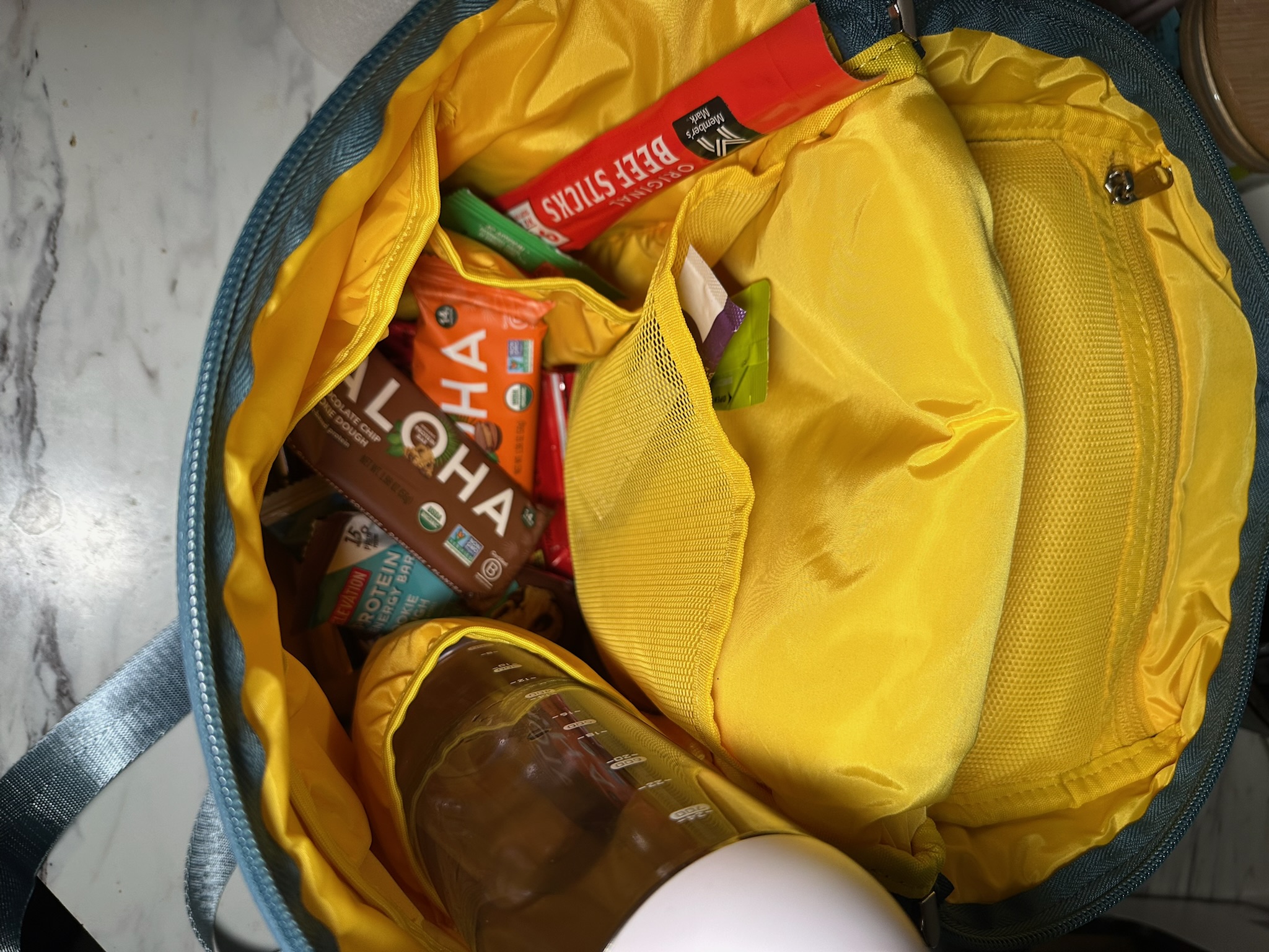 Soft sided insulated cooler bag filled with snacks and drinks, lightweight travel cooler for busy moms and family outings