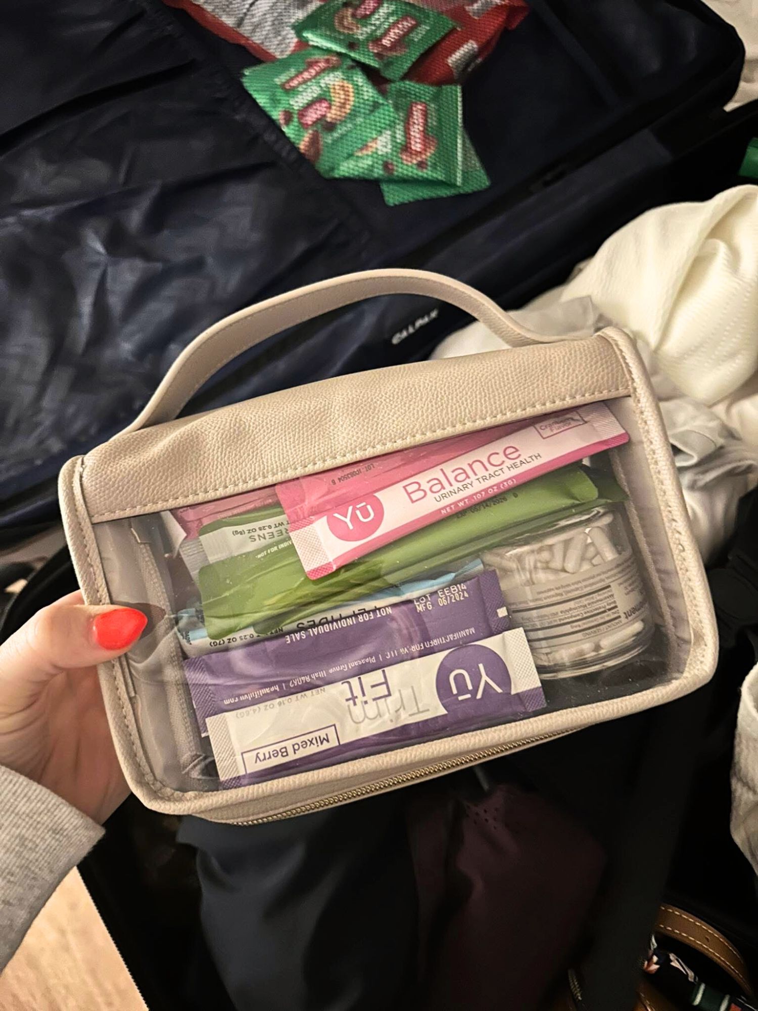 Clear travel pouch filled with Yū Nutrition supplements and wellness essentials, showing a busy mom’s organized daily routine for metabolism support and healthy lifestyle habits.
