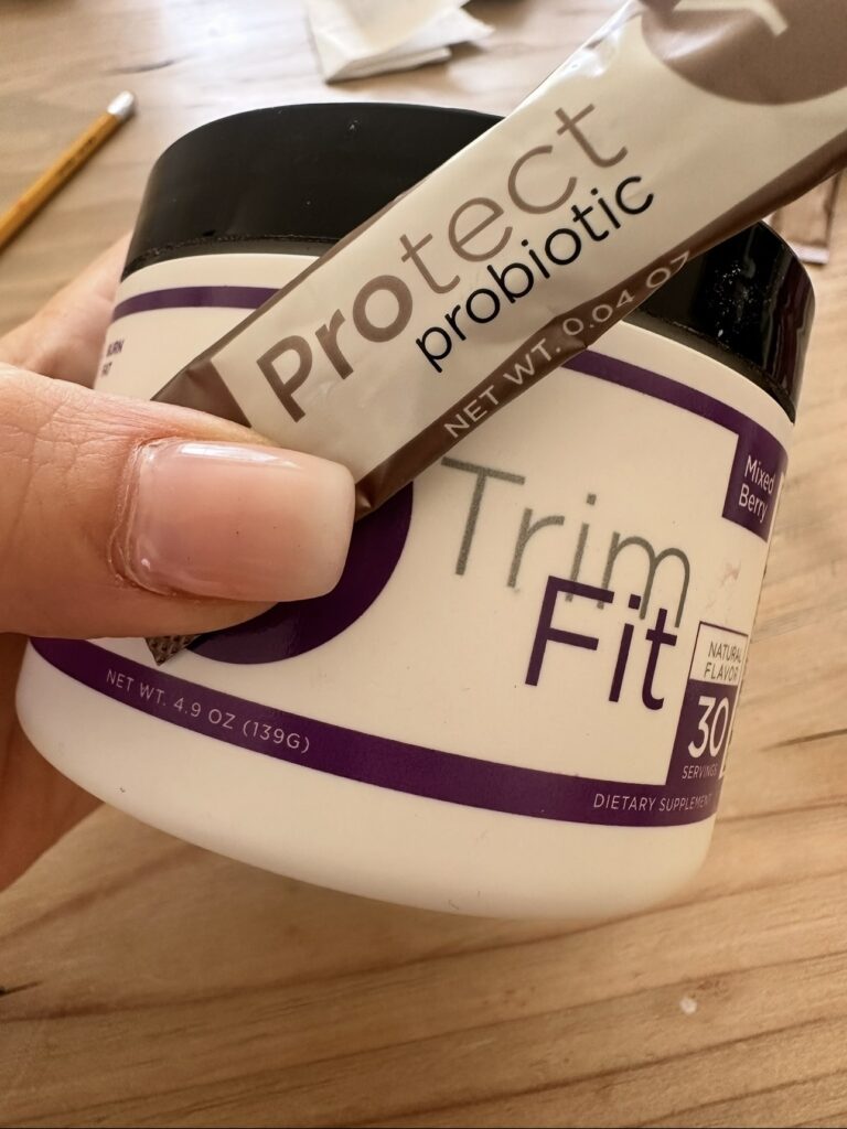 Yū Nutrition TrimFit purple tea and Protect Probiotic supplements shown together as part of a busy mom metabolism support and sustainable weight loss routine.